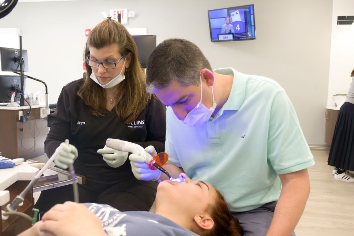 Dr. Ollins putting attachments on a patient's teeth