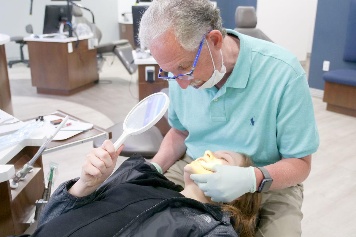 Dr. Ollins showing a patient their teeth in a mirror